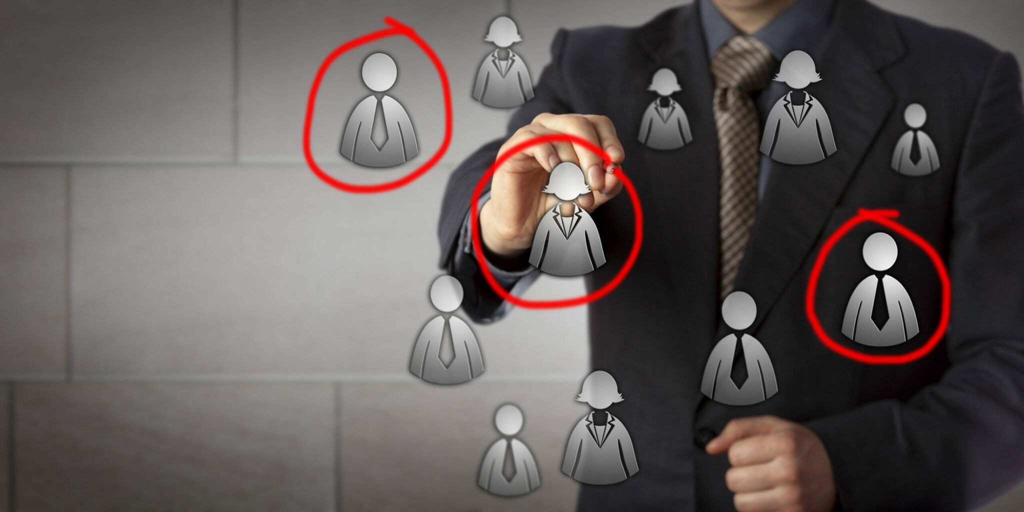Blue chip marketing manager is circling three candidates in a group of male and female white collar icons. Business concept for target audience market segmentation sales prospecting and recruiting.